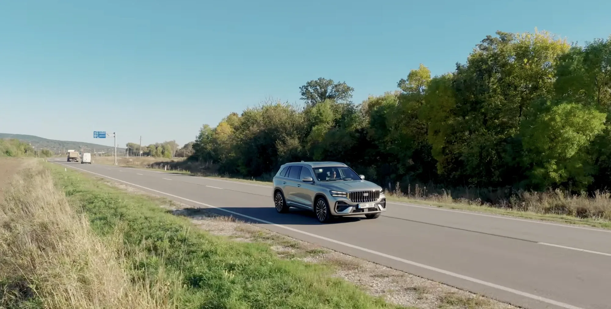 Geely Monjaro EM-i цвета Sunlight Gold на загородной дороге в Молдове